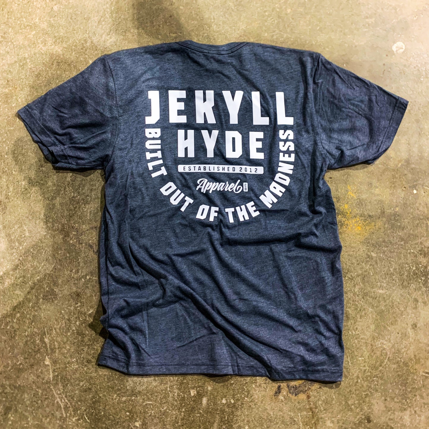 A grey tshirt with white print on the floor. 