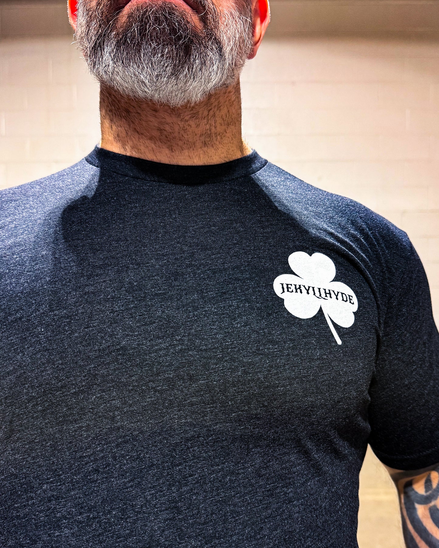 Person wearing a black t-shirt with a white logo on the chest.