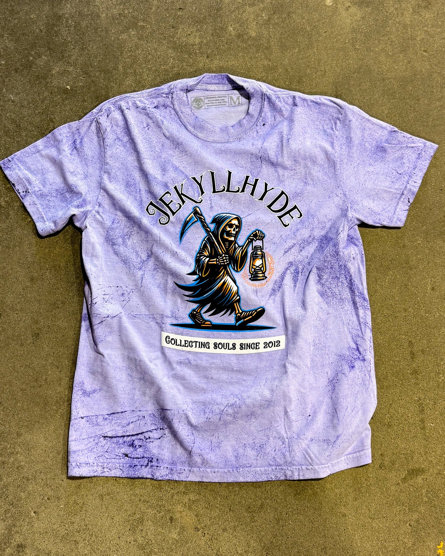Purple t-shirt with a graphic design of a Grim Reaper and text on a beige background