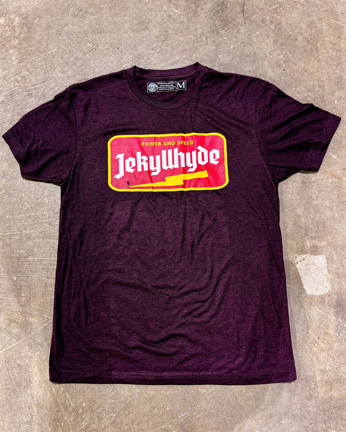 flat lay of maroon tshirt with lightning bolt and jekyllhyde name. 