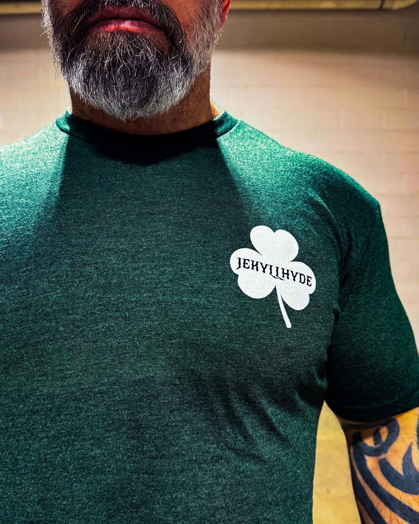 Person wearing a green shirt with a white shamrock logo featuring 'Jekyll & Hyde' text.