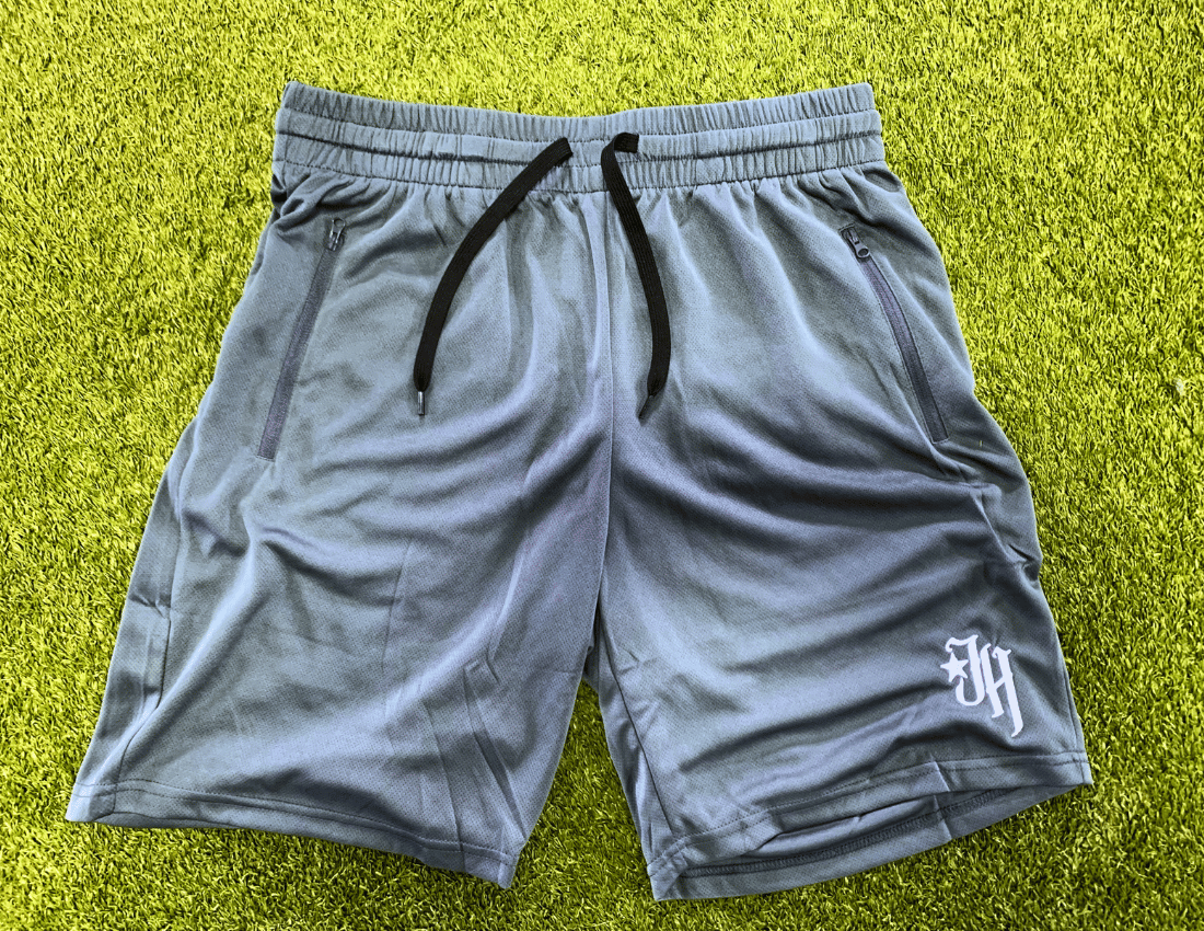 Dark grey shorts flat laid on turf. 