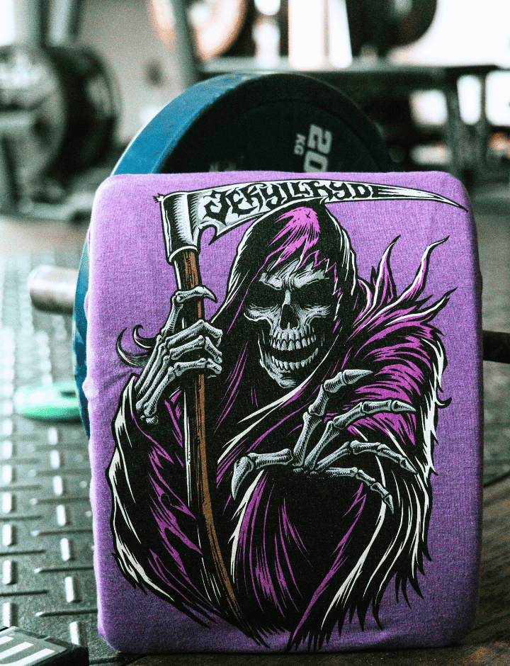 A purple shirt with a grim reaper on it propped up against a barbell. 
