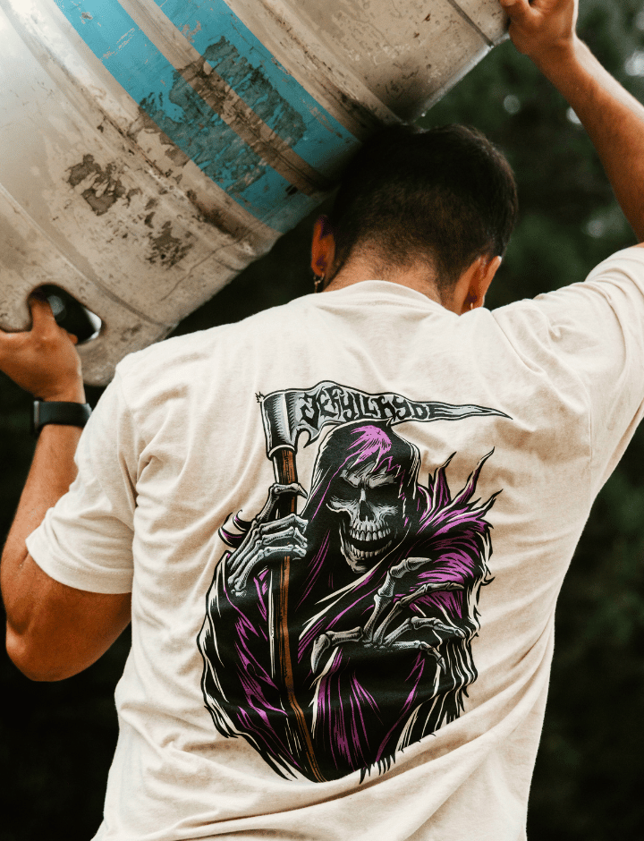 Man holding a keg above his head wearing a sand colored shirt with a grim reaper on it. 