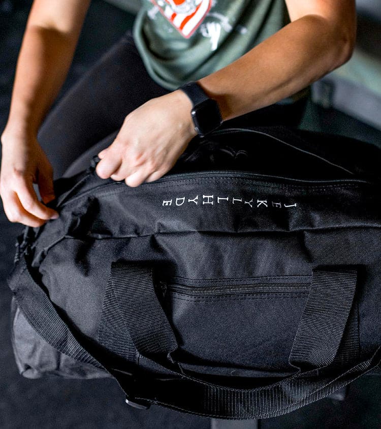 Person zipping closed a duffle bag
