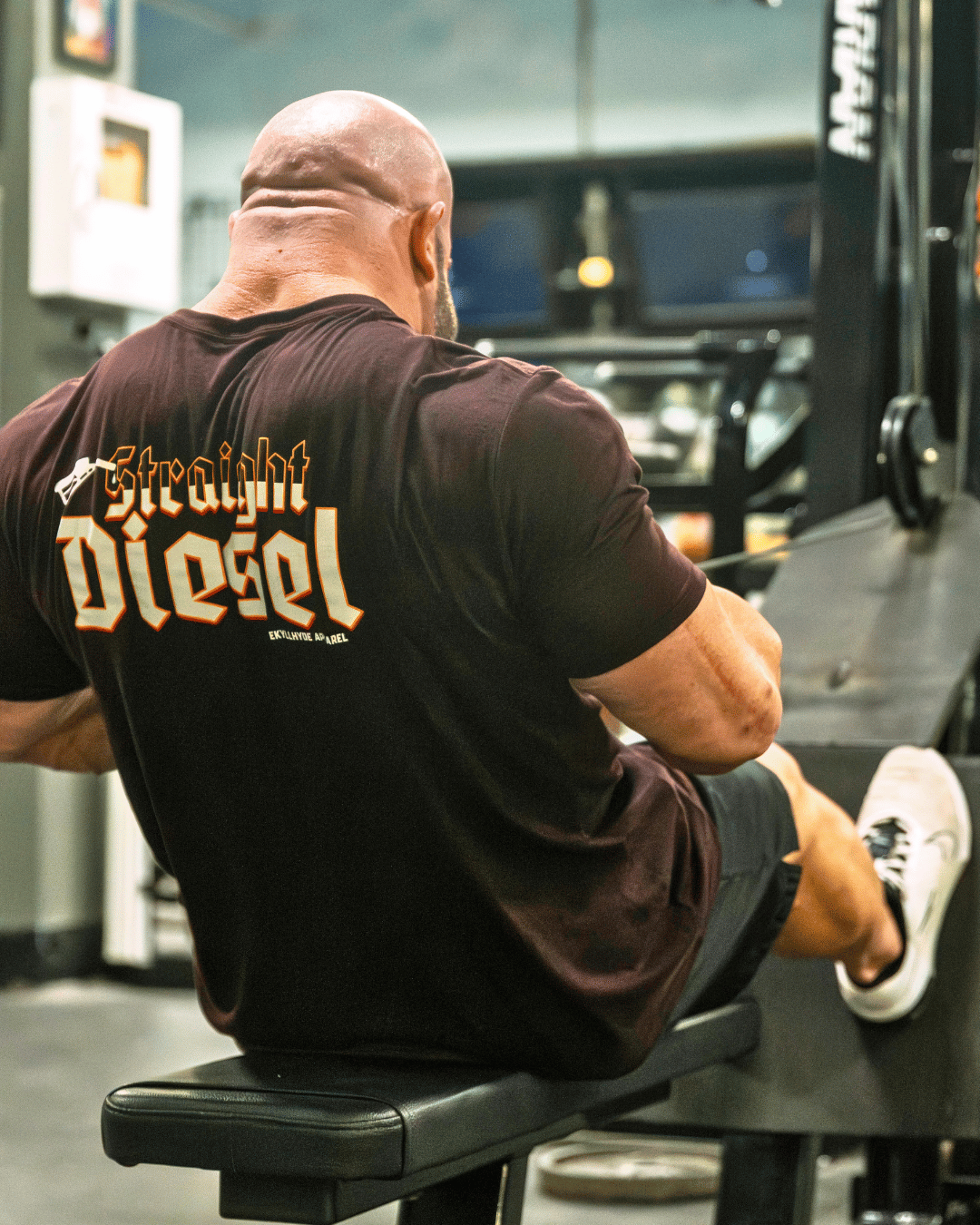 Muscular man doing seated rows in maroon tshirt. 