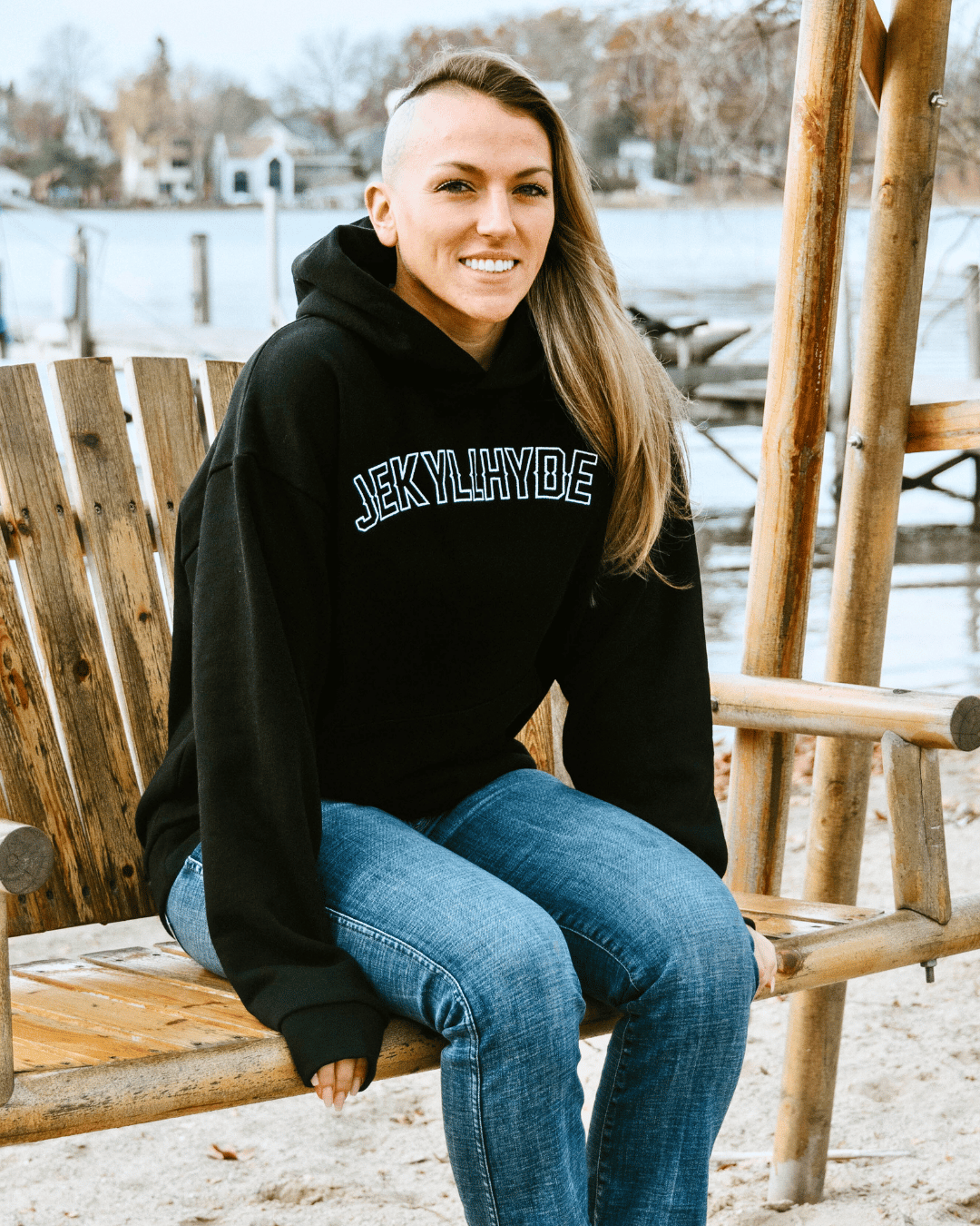 Woman sitting on a bench swing wearing a black hoodie. 