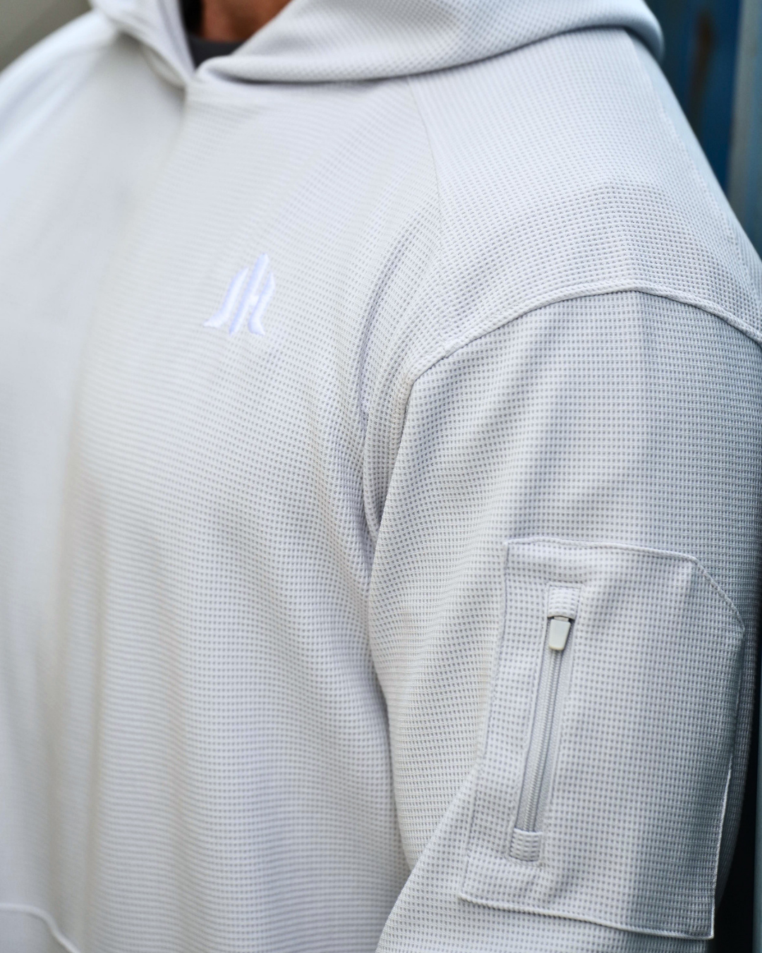 Close up of a light grey hoodie and the waffle knit textured fabric. 