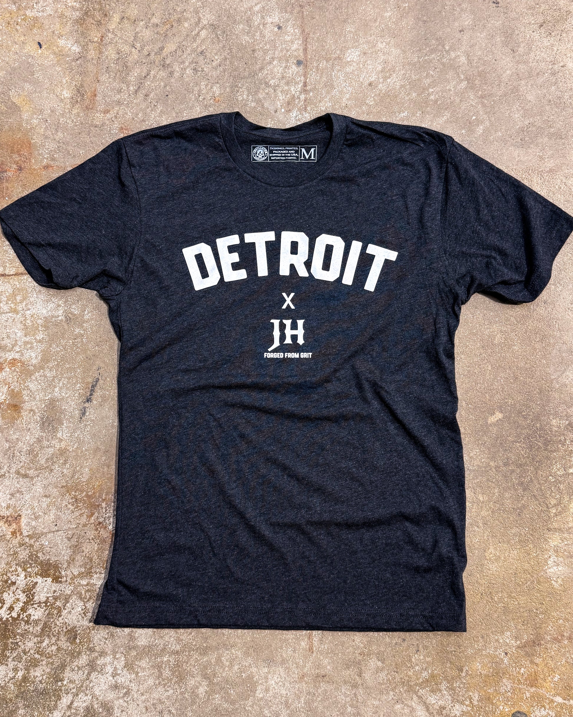 Black t-shirt with 'DETROIT' and 'JH' text on a textured surface
