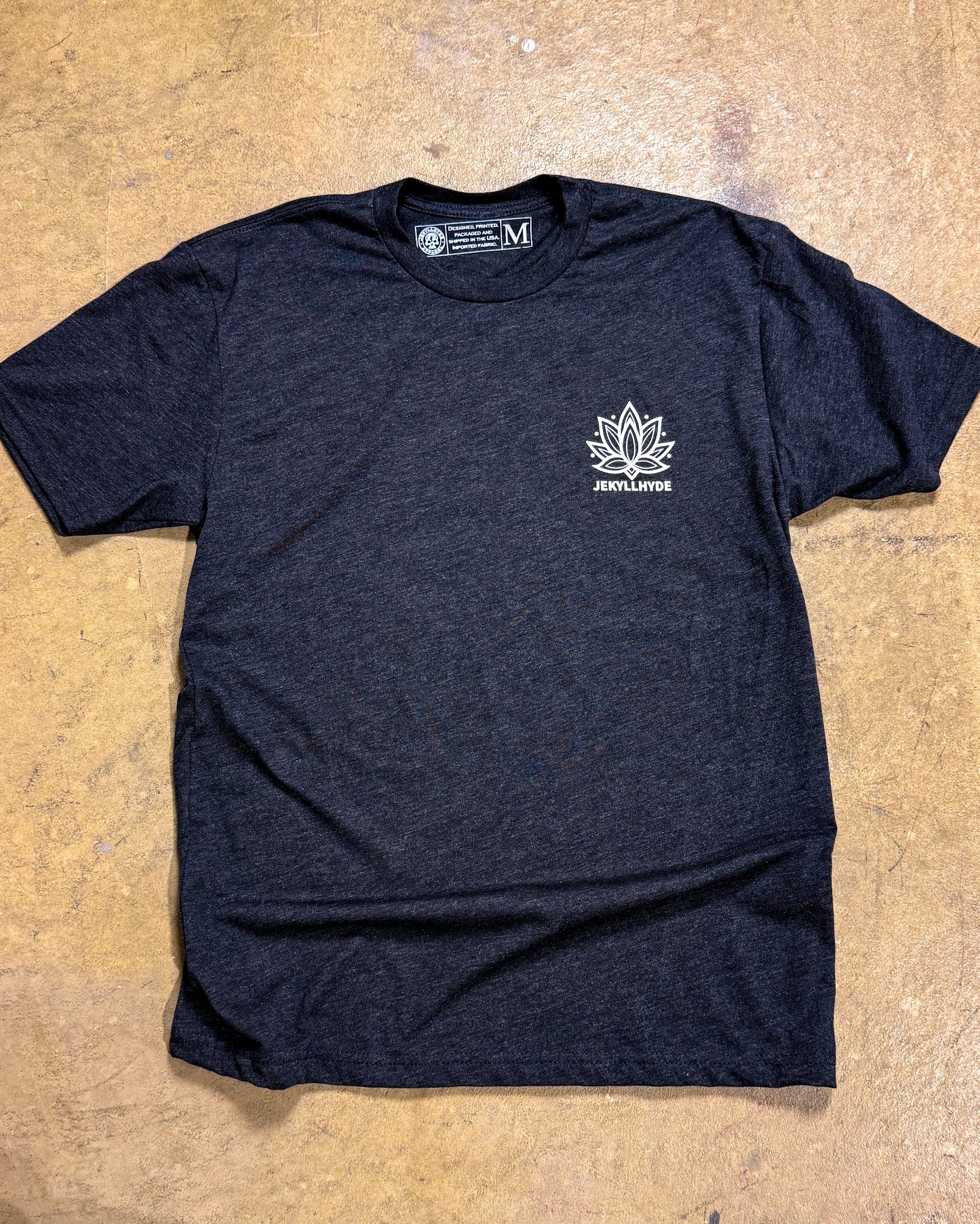 Black t-shirt with a white logo on a beige surface