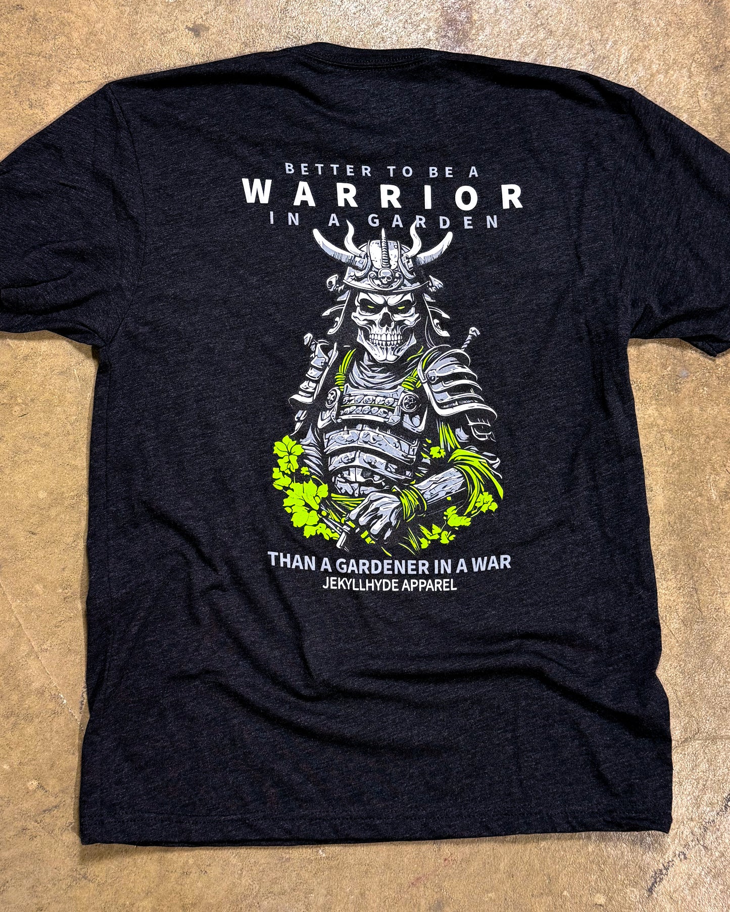 Black t-shirt with warrior graphic and text on a textured surface