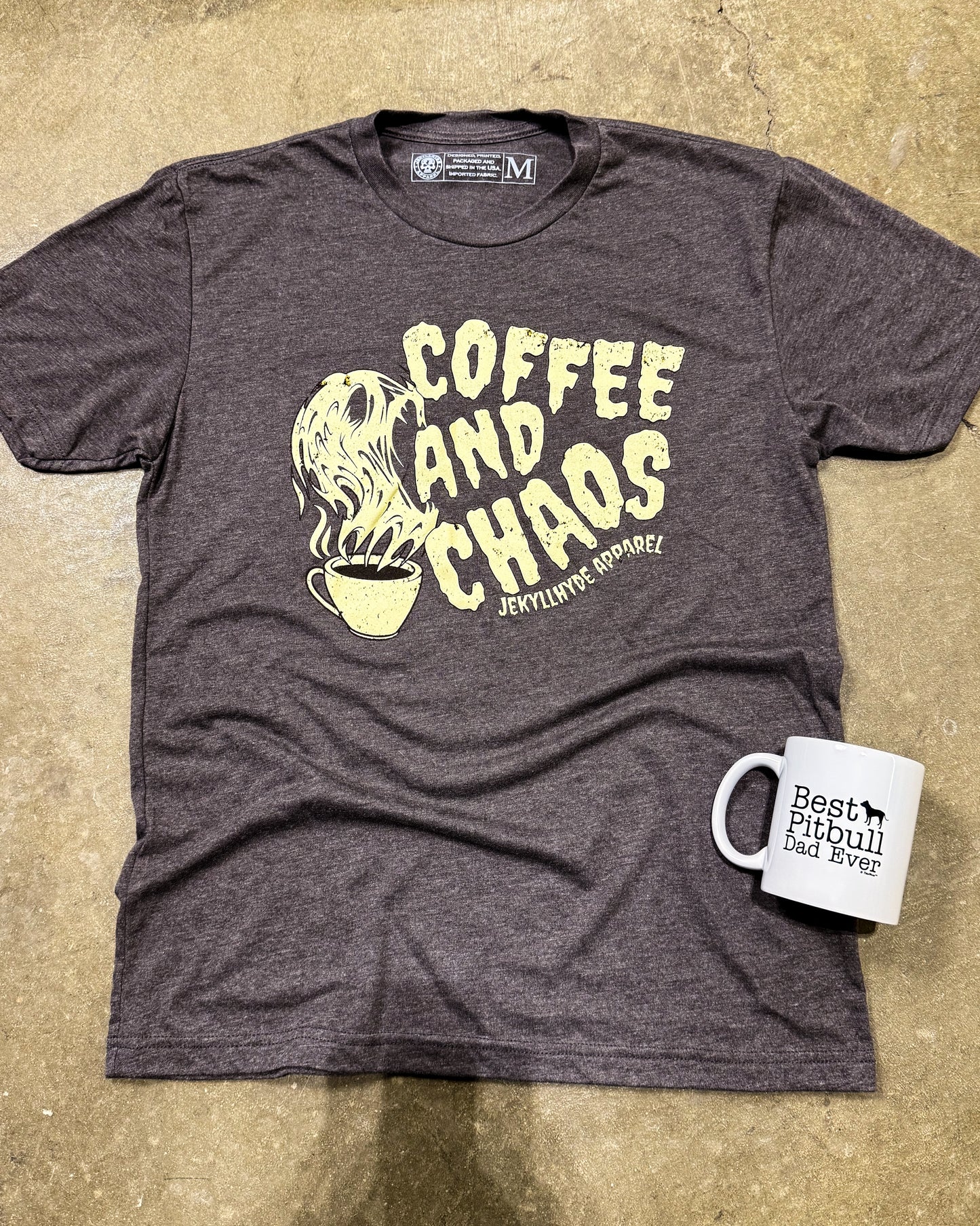 Gray t-shirt with 'Coffee and Chaos' graphic and a mug on a beige surface