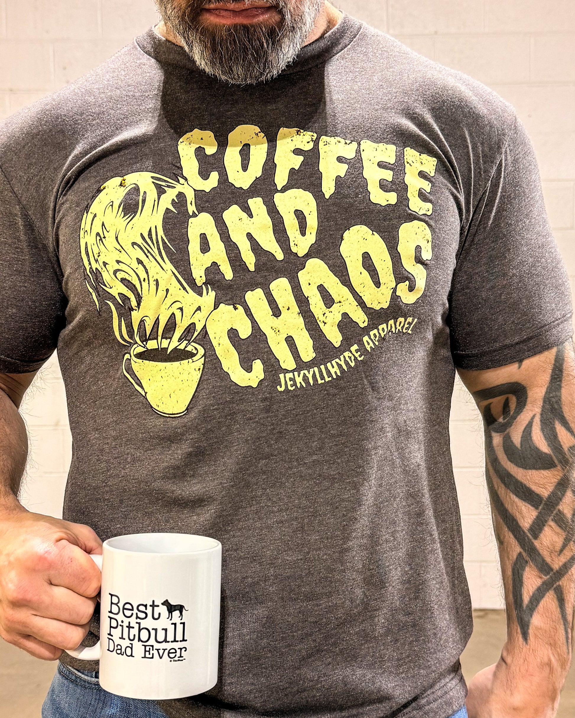 Person wearing a t-shirt with 'Coffee and Chaos' design and holding a mug.