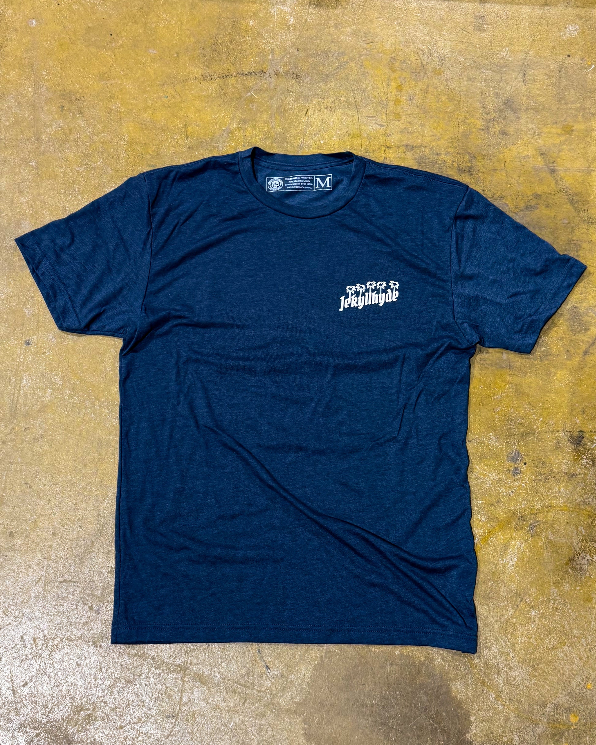 Blue t-shirt with white text on a textured yellow-brown surface