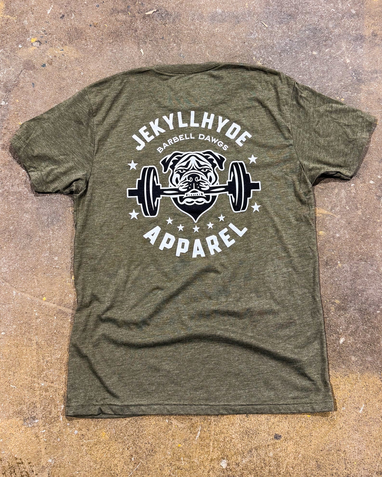Green t-shirt with 'Jekyll Hyde Apparel' logo featuring a bulldog lifting weights on a textured surface.