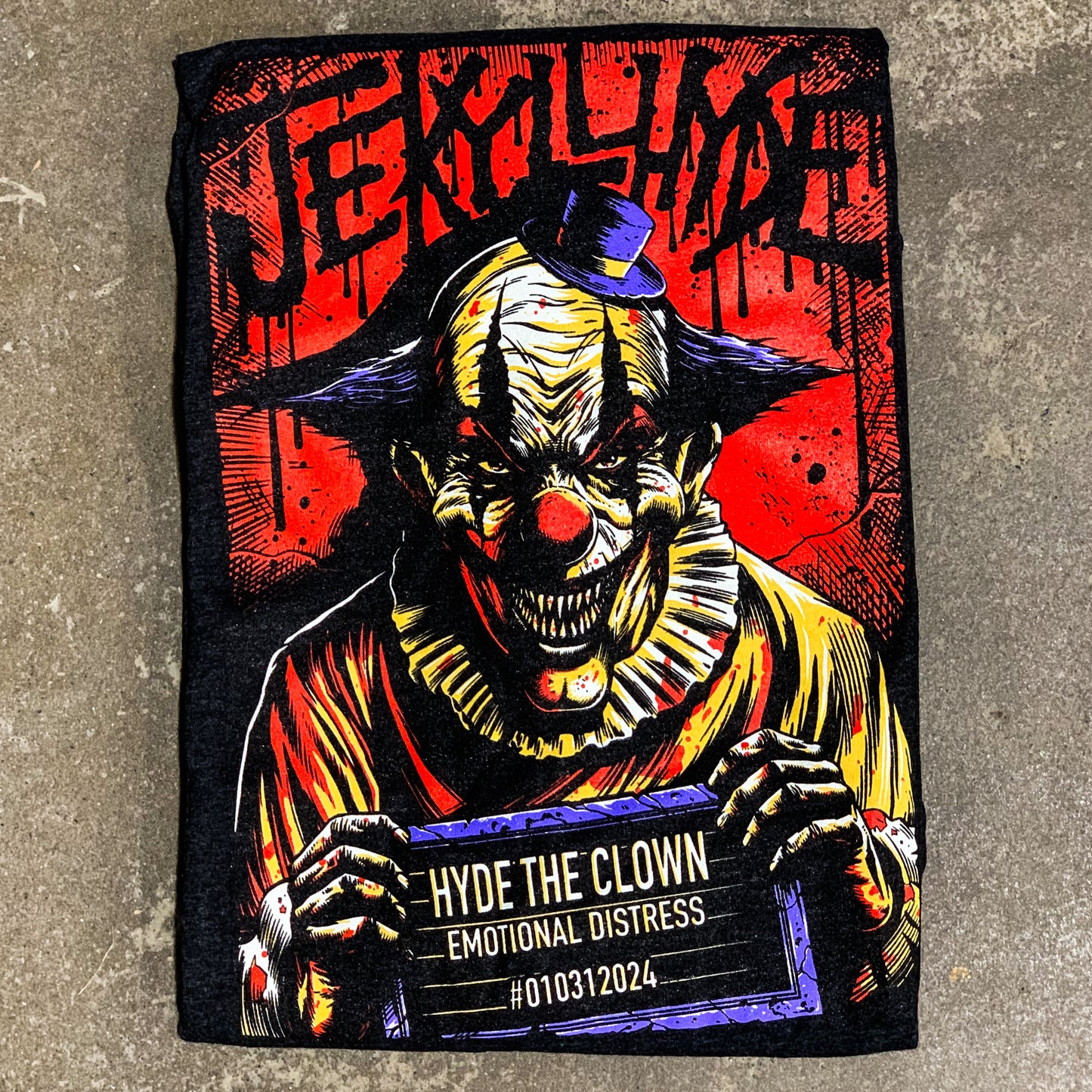 Folded tshirt with a demonic clown laying on the concrete. 