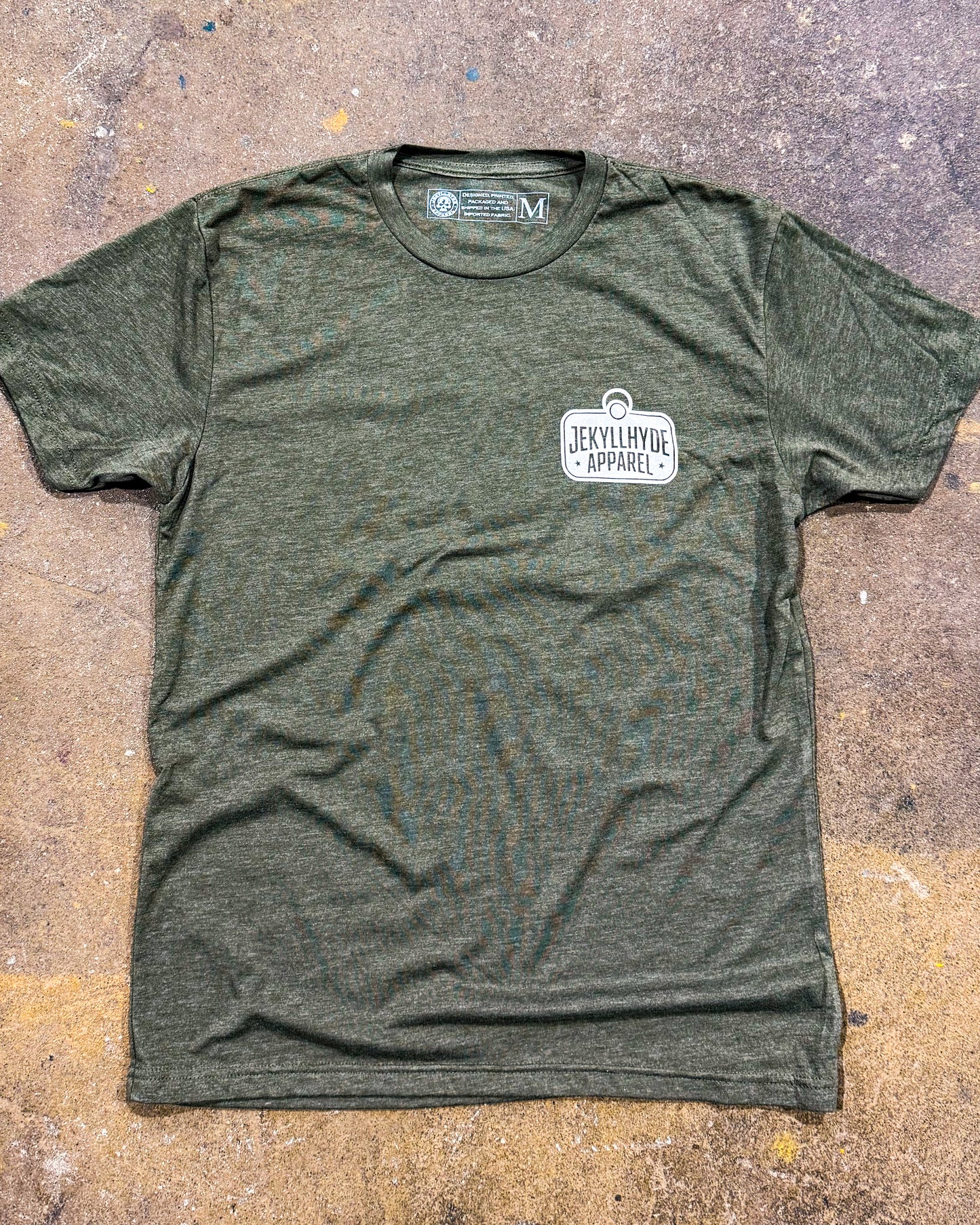 Green t-shirt with a logo on a textured surface