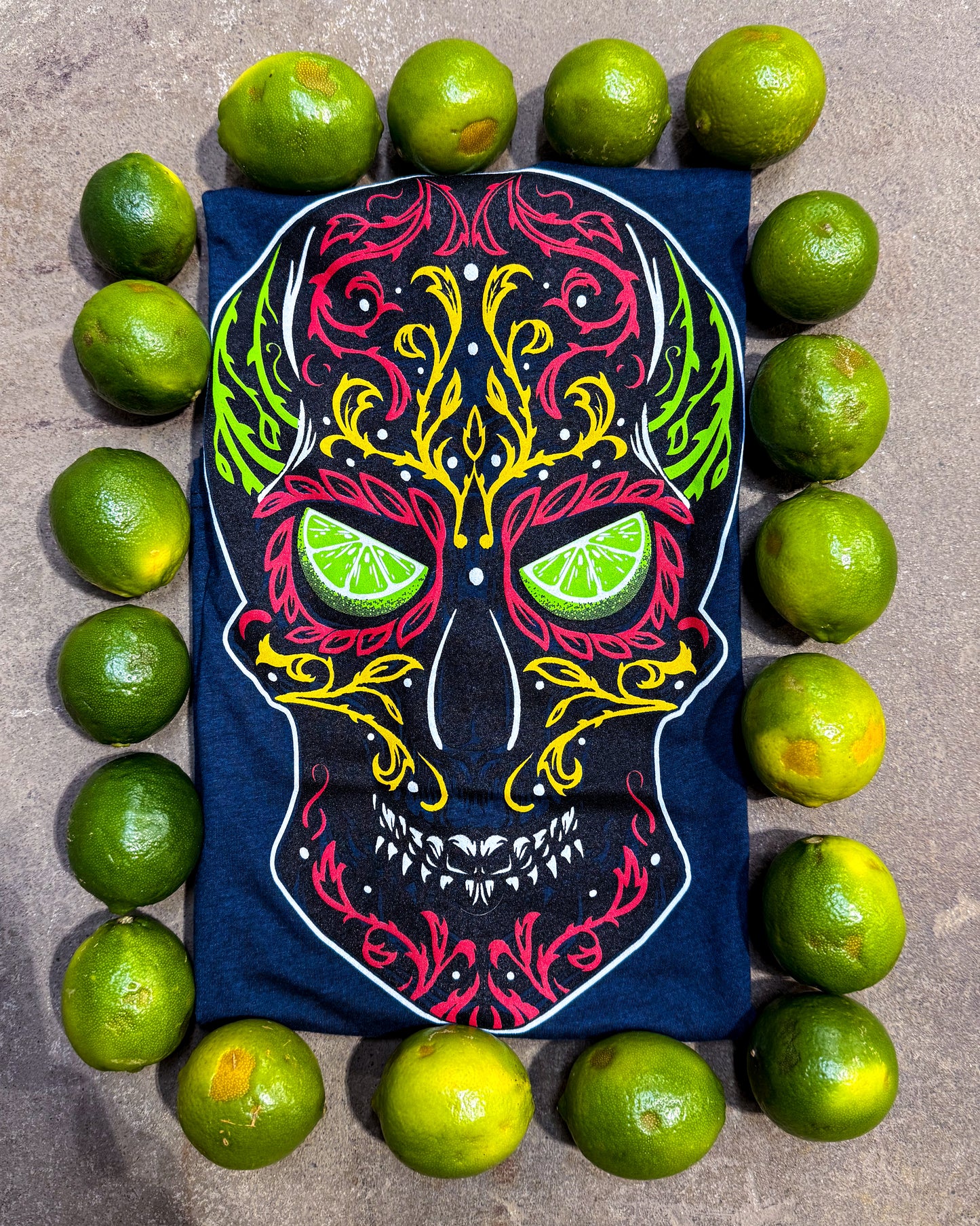 Colorful skull design on a blue background surrounded by limes.