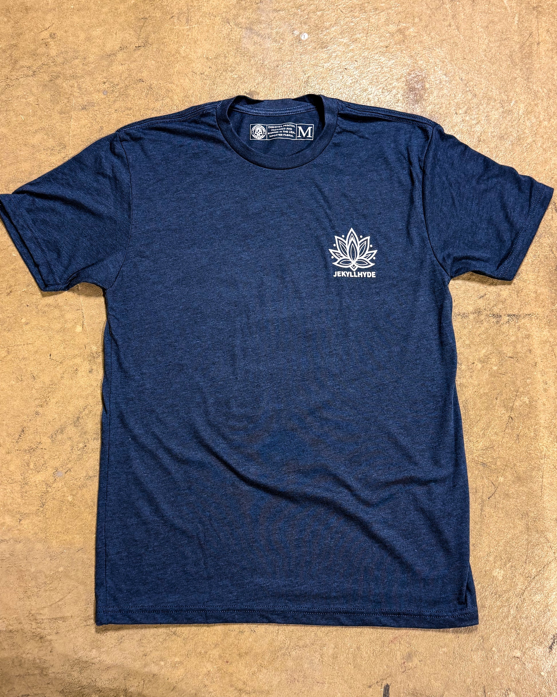 Blue t-shirt with a white logo on a beige surface