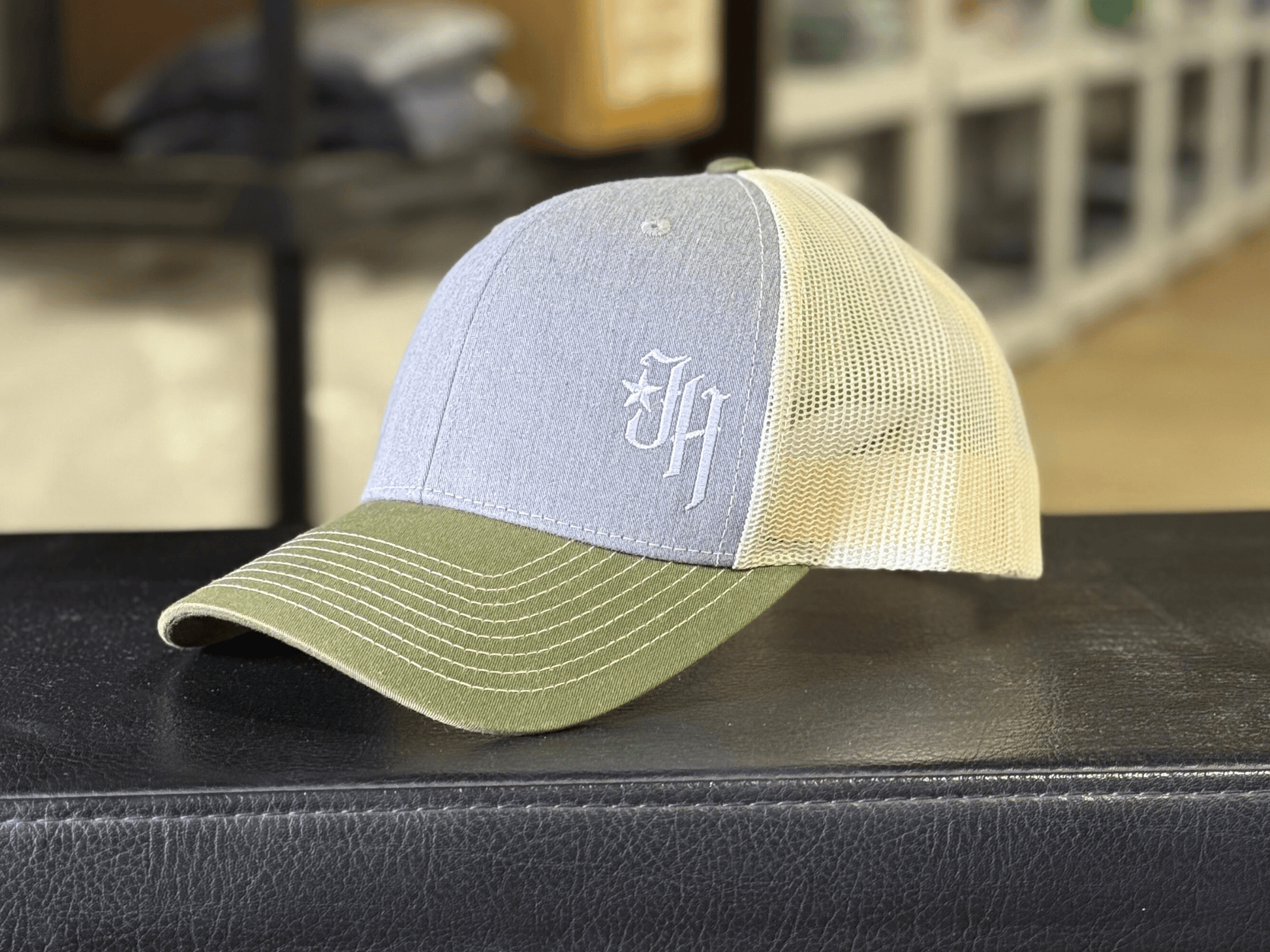 Trucker hat with grey and green design on a black surface