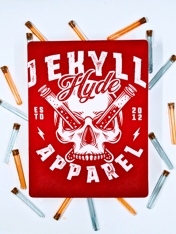 A red shirt on a white background with a skull on it and test tubes going through the eyes. 