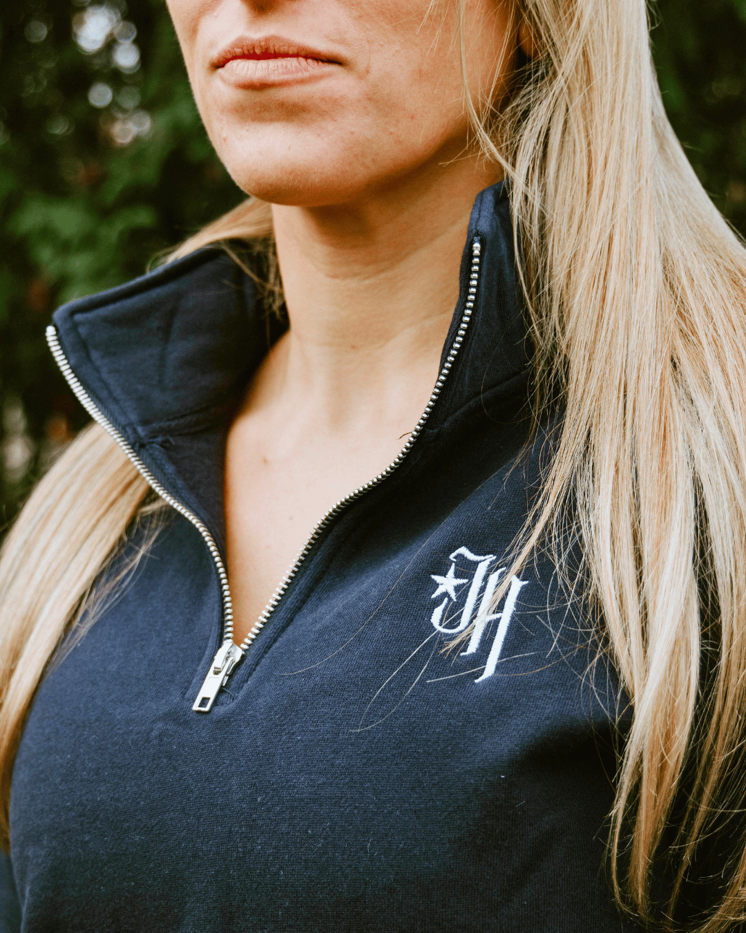 Unzipped navy quarter zip sweatshirt on a woman.