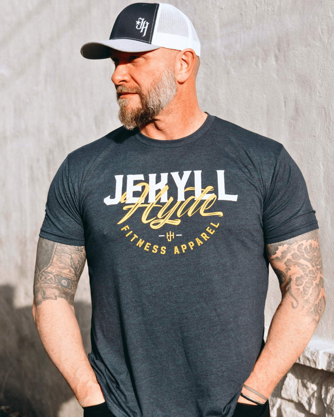 Man standing with his hands in his pockets looking off to the side wearing a Jekyllhyde tshirt. 