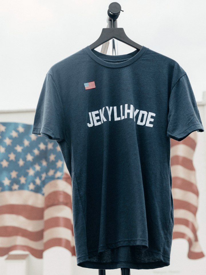 Navy shirt on a hanger with the American flag in the background. 