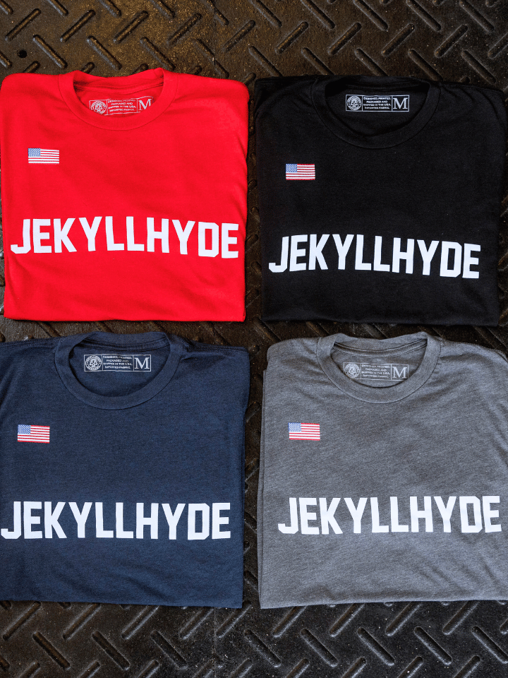 4 tshirts folded in a square on a rubber floor. 
