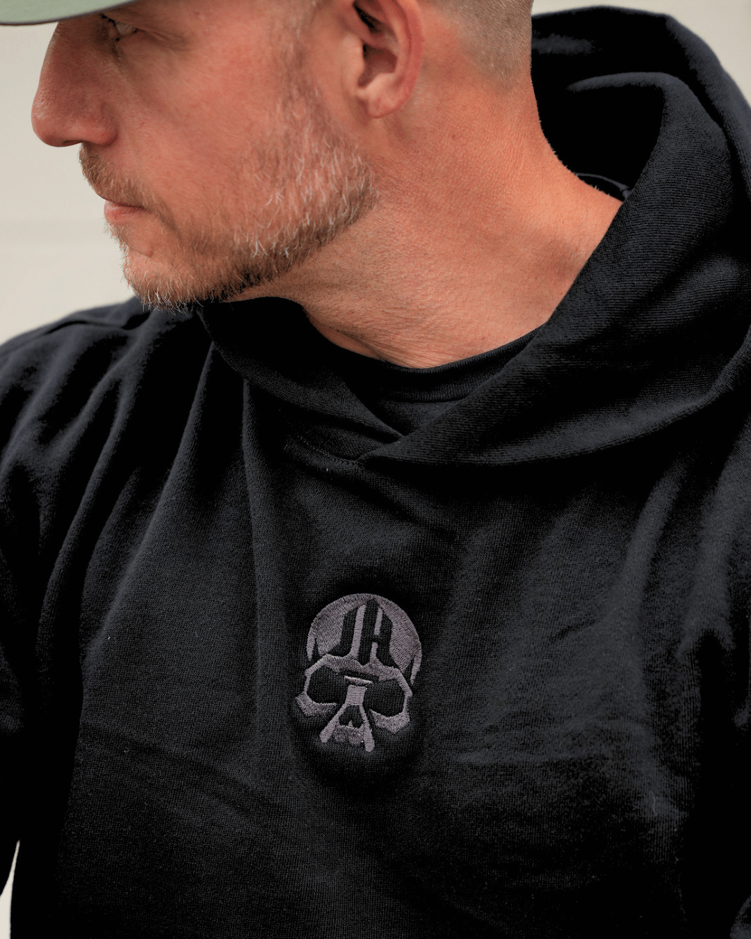 Close up of embroidered skull logo on a black hoodie. 