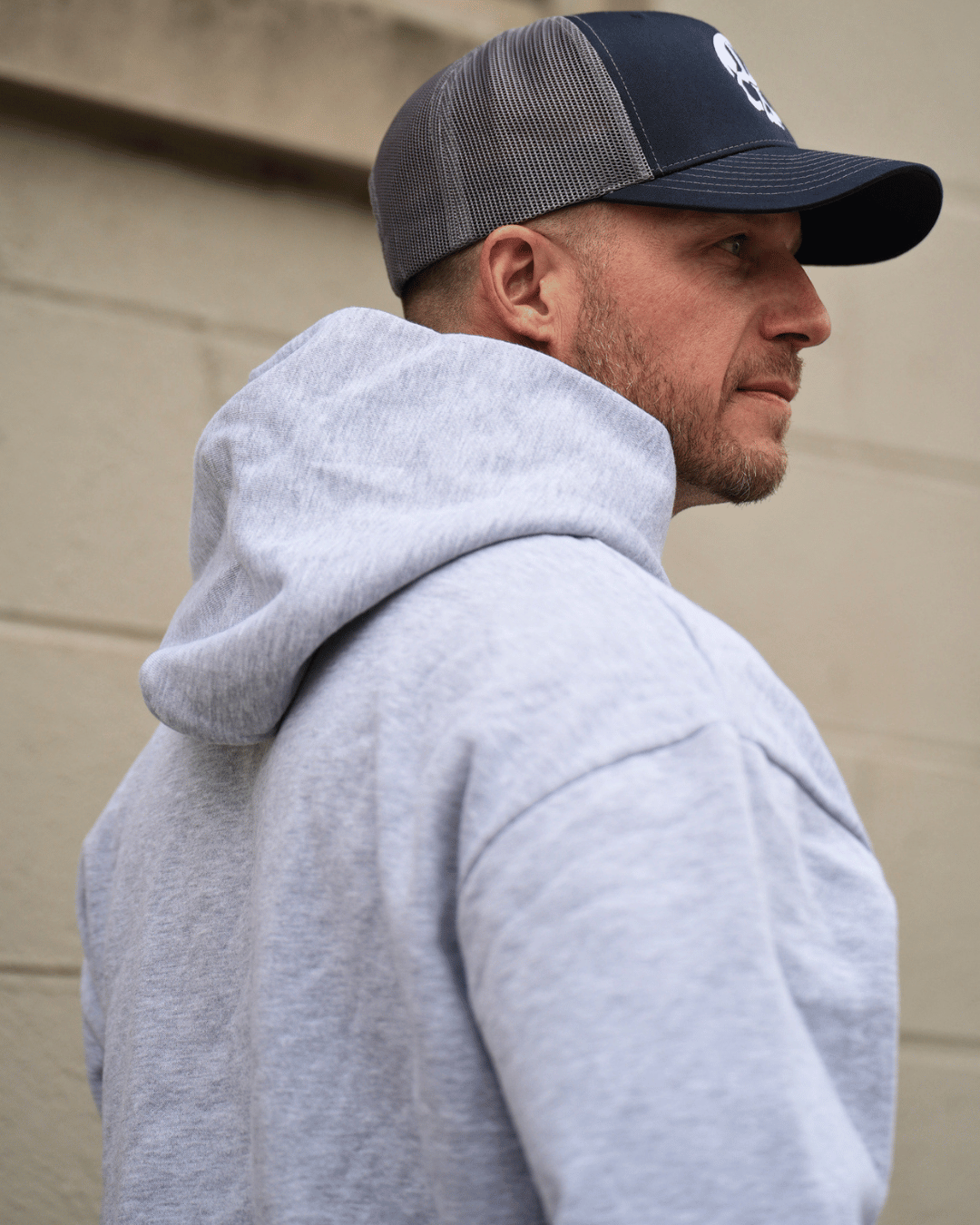 Man looking off wearing a grey hoodie. 