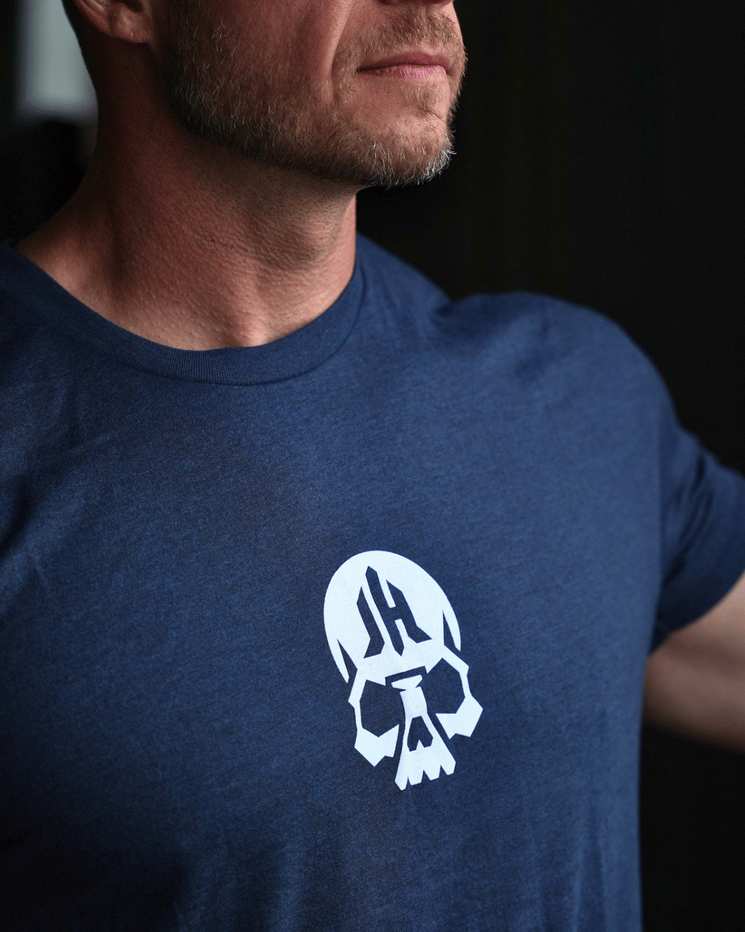 Close up of a skull on the chest of a navy shirt. 