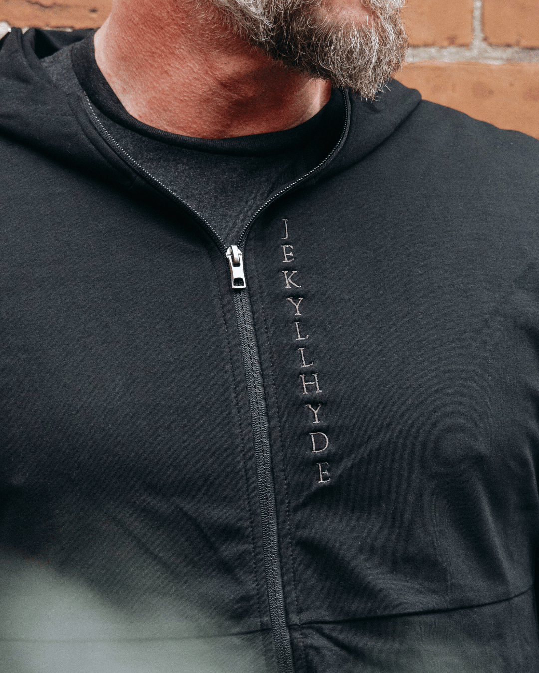 Close up of a black jacket neckline with vertical Jekyllhyde embroidery. 