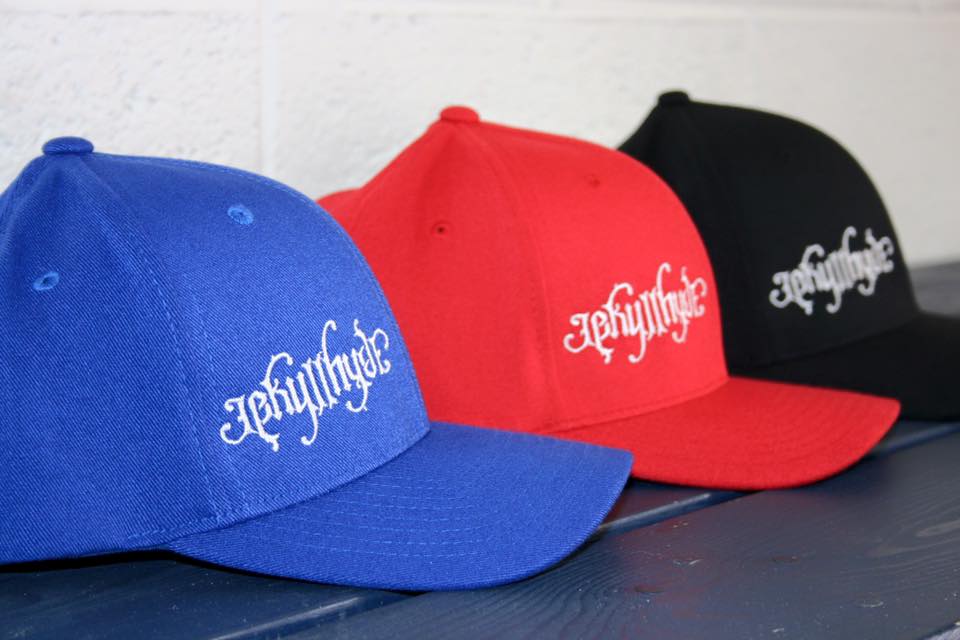 3 baseballs hats lined up diagonally with a Jekyllhyde logo on them.  