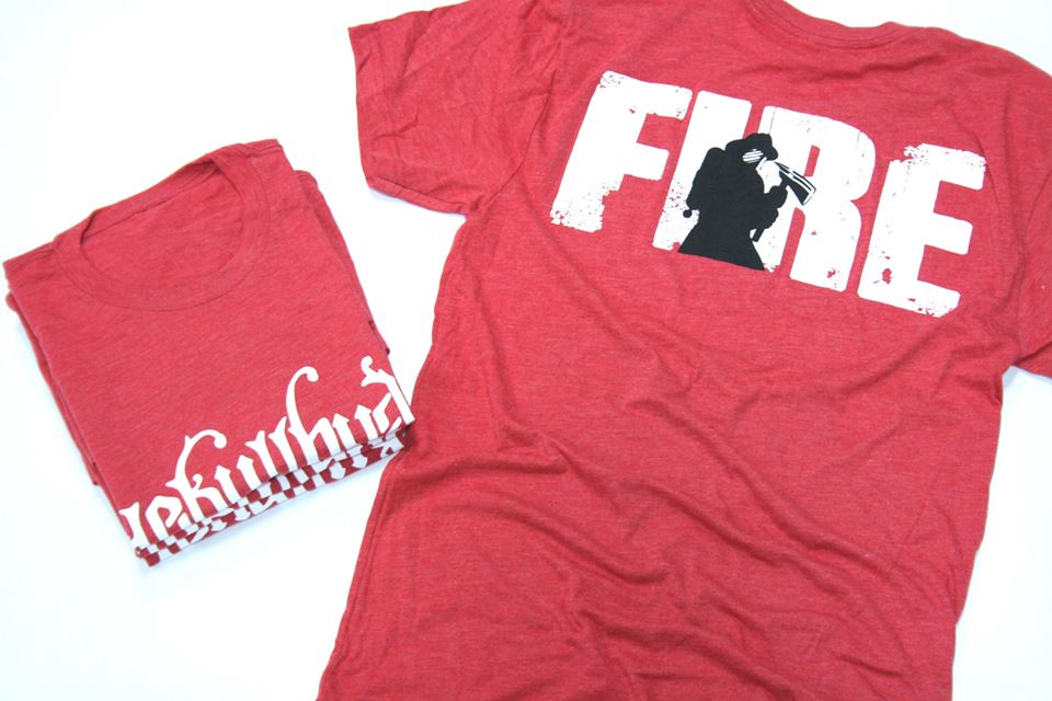 Red shirt on the ground with a print that says "FIRE" and a silhouette of a fireman. 