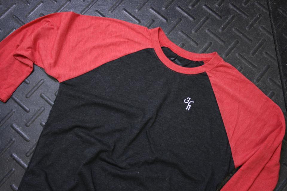 Flat lay of red and black raglan on black rubber flooring. 