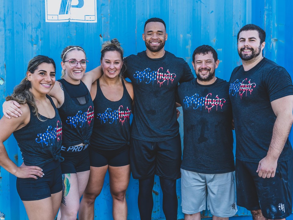 A group of sweating friends standing together in red, white and blue jekyllhyde tshirts. 