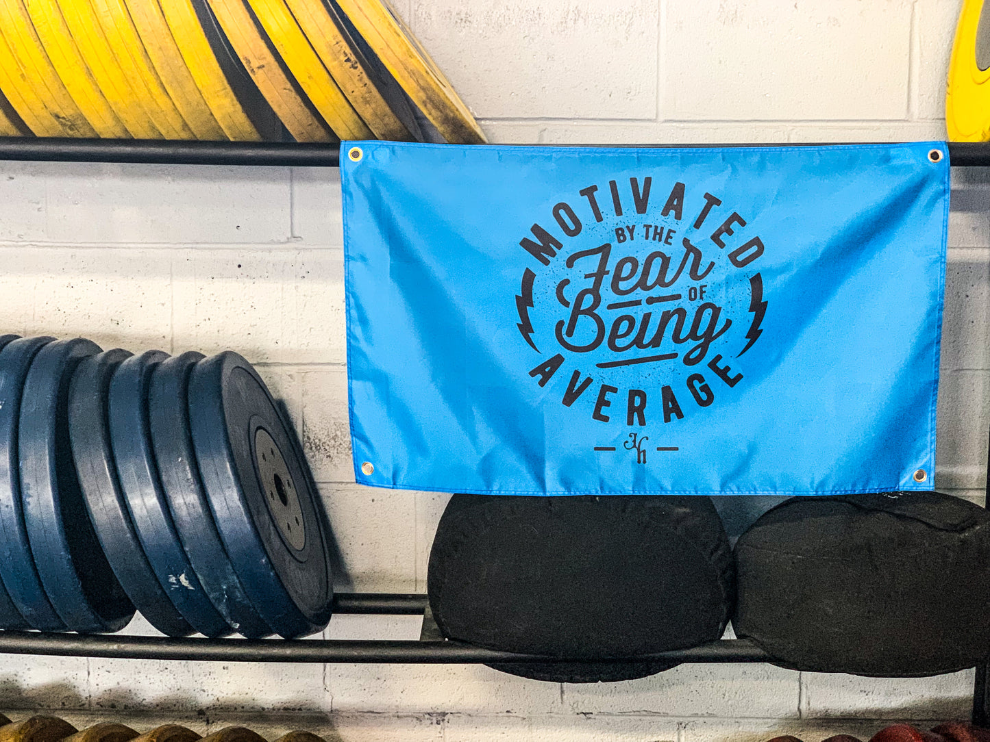 A blue gym flag hanging from a weight rack. 