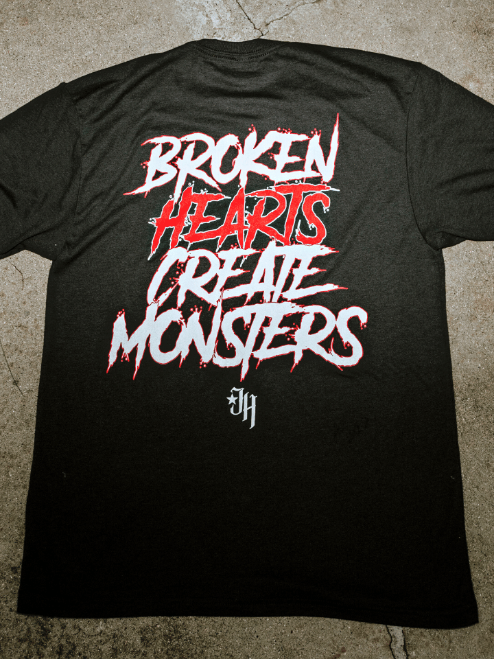 Flat lay of a tshirt on concrete with the words "Broken hearts create monsters" on shirt. 