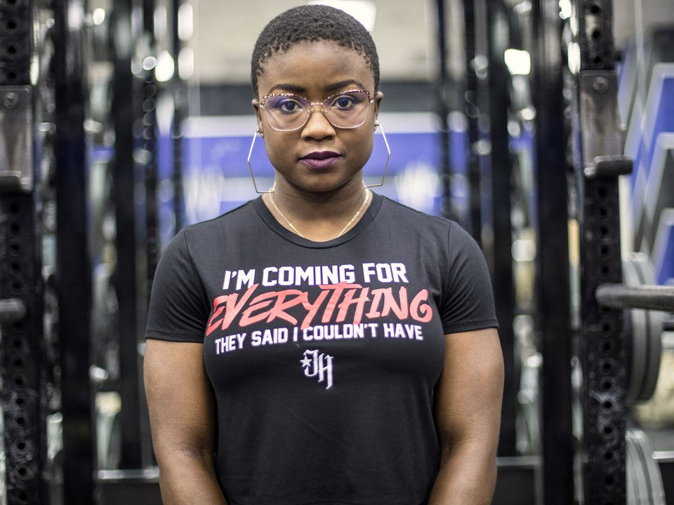 Girl in a gym staring at the camera wearing a crop top that says "Im coming for everything they said I couldn't have"