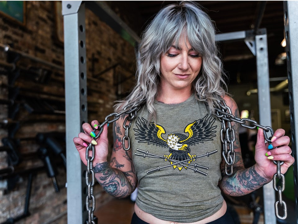 Woman wearing a shirt with an eagle and barbells. 
