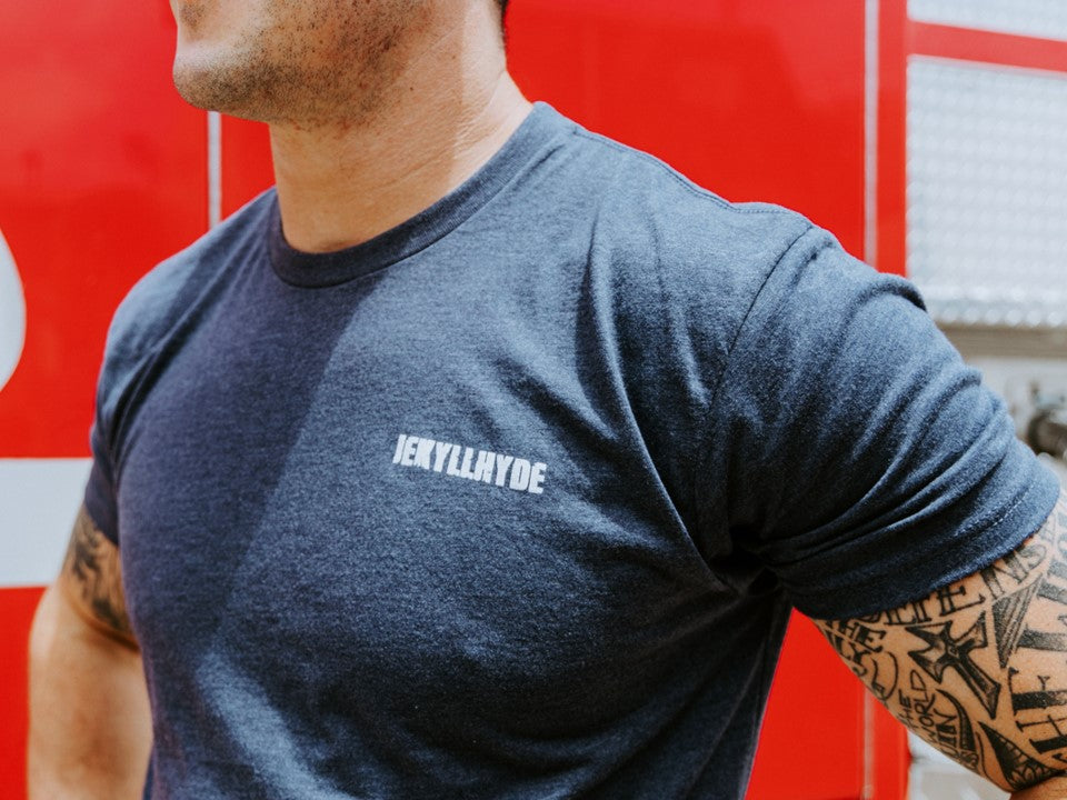 Close up of the front of a blue tshirt with a Jekyllhyde logo on the left chest. 