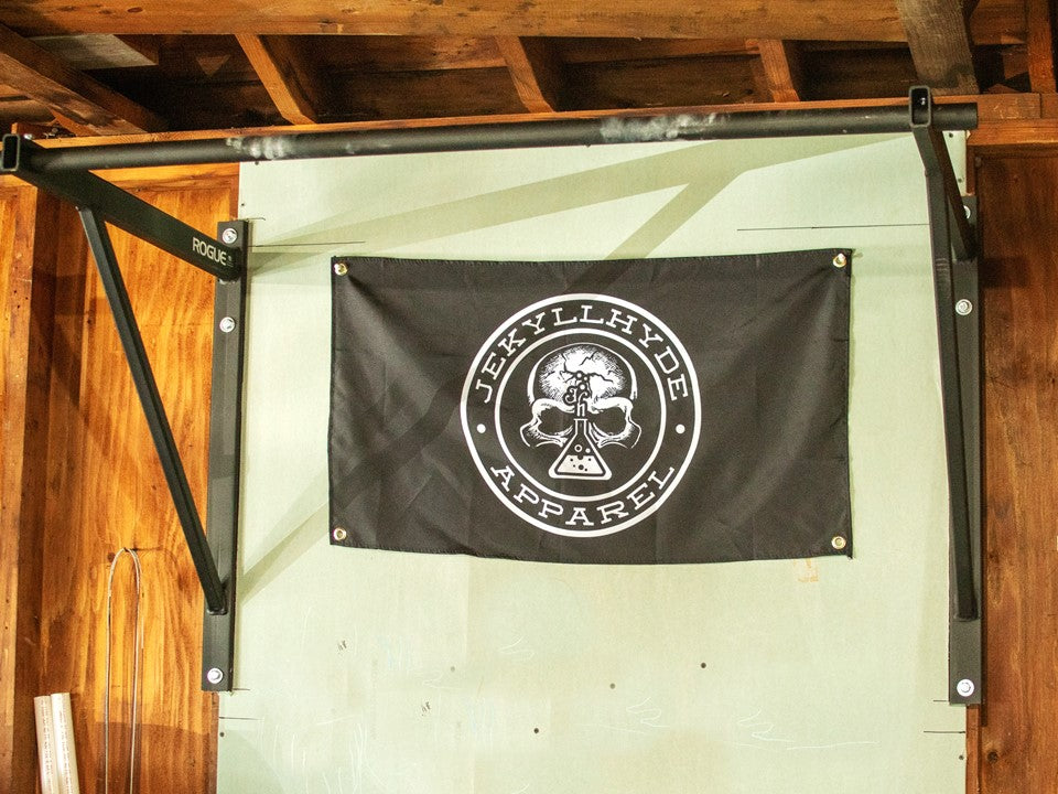 A black gym flag hanging inside a garage gym. 