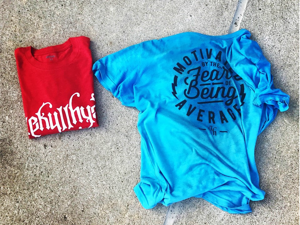 Blue and red tshirt laying on the cement. 