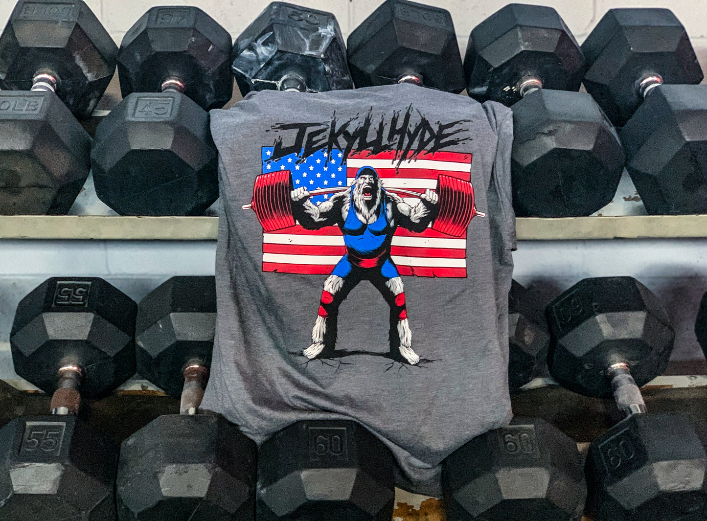 Grey tshirt hanging from a dumbbell rack. 