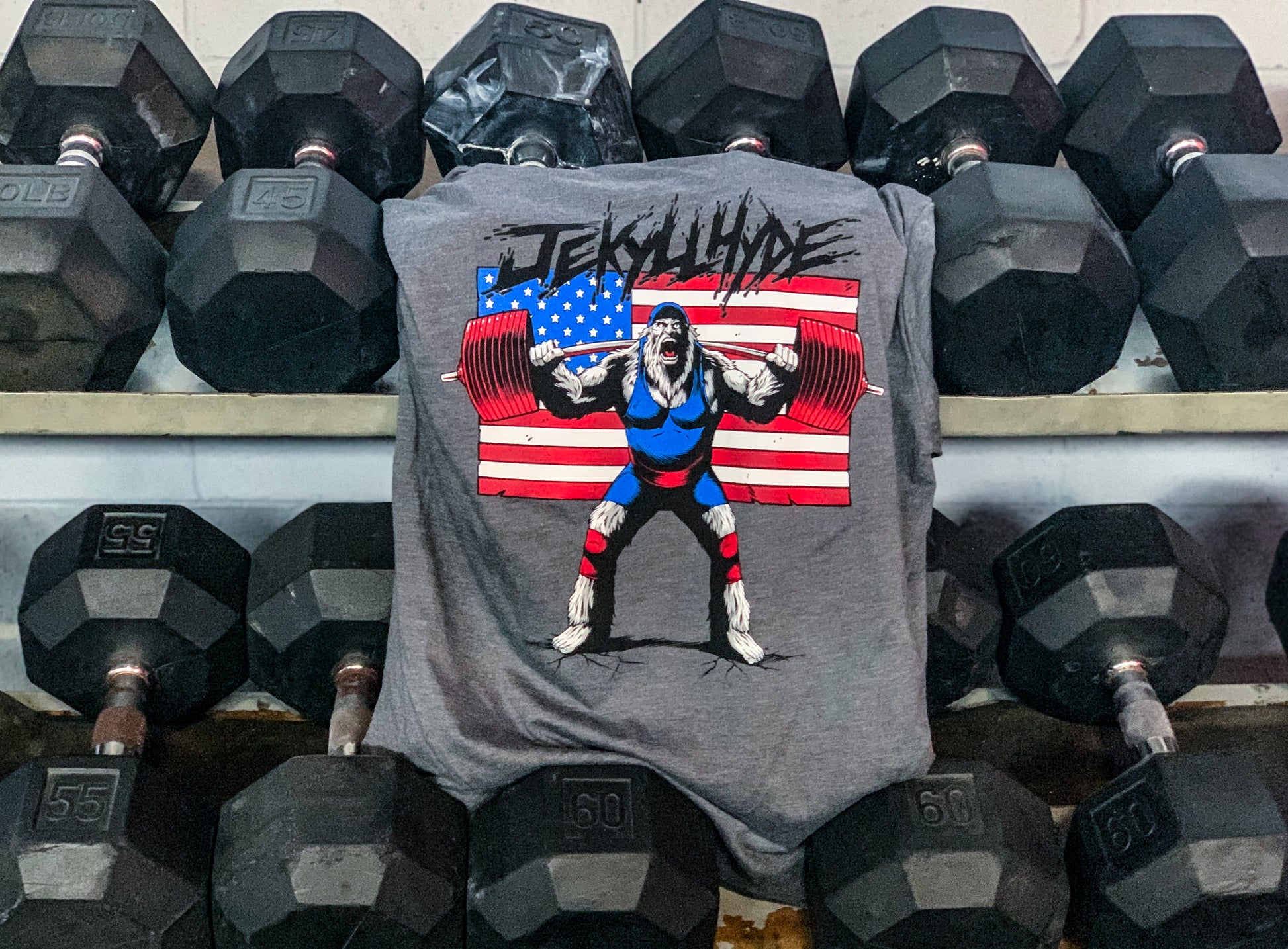 Grey tshirt hanging from a dumbbell rack. 