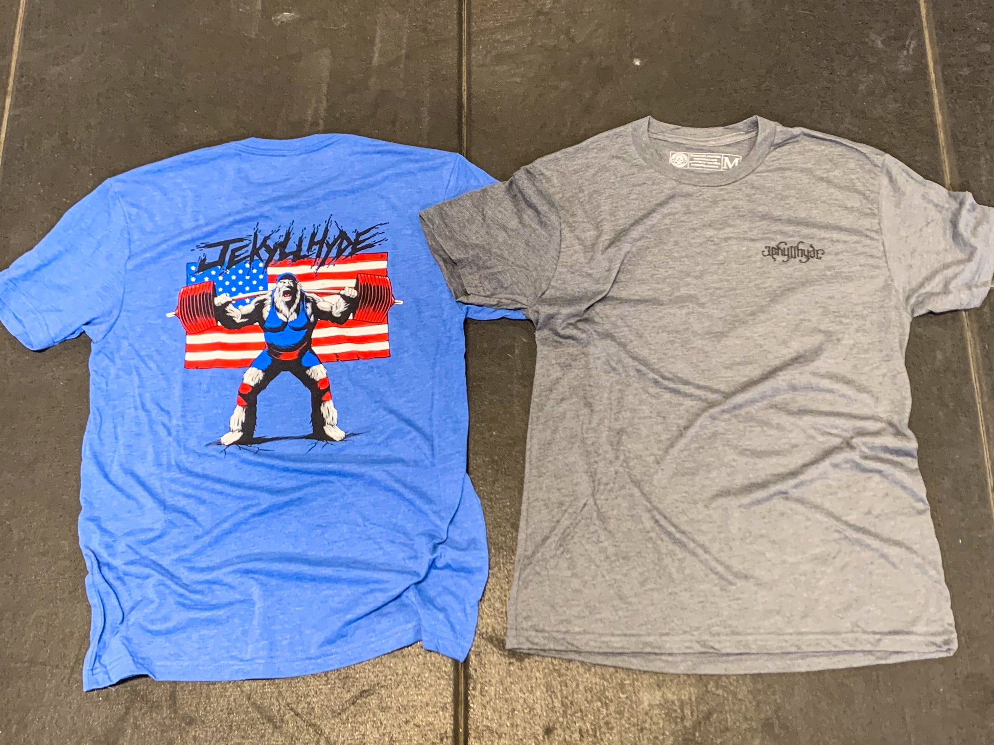 Grey and blue tshirt laying on the ground. 