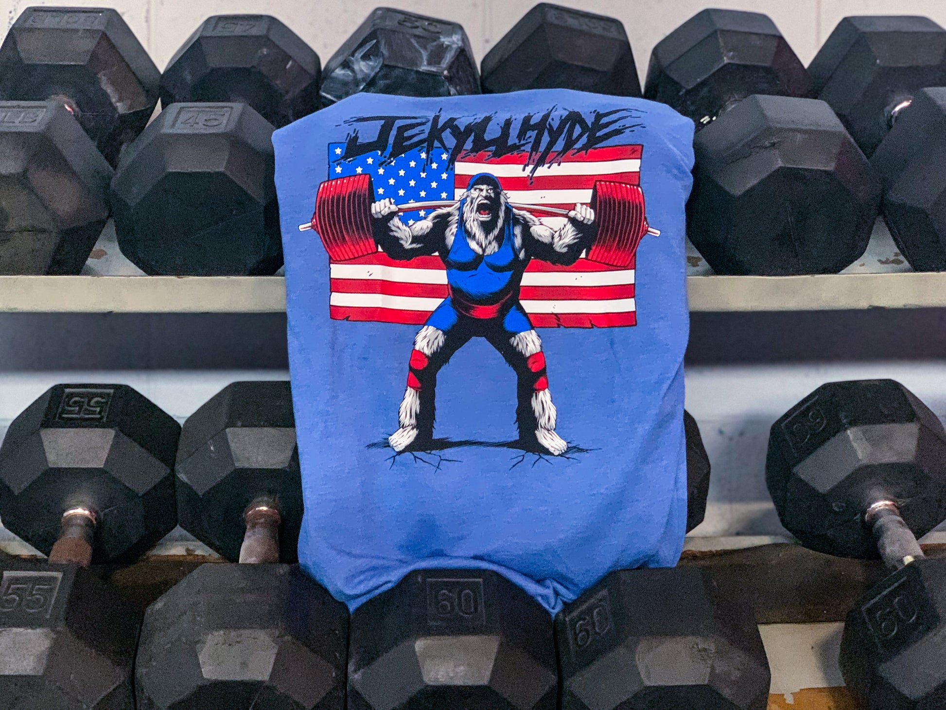Blue tshirt hanging from a dumbbell rack. 