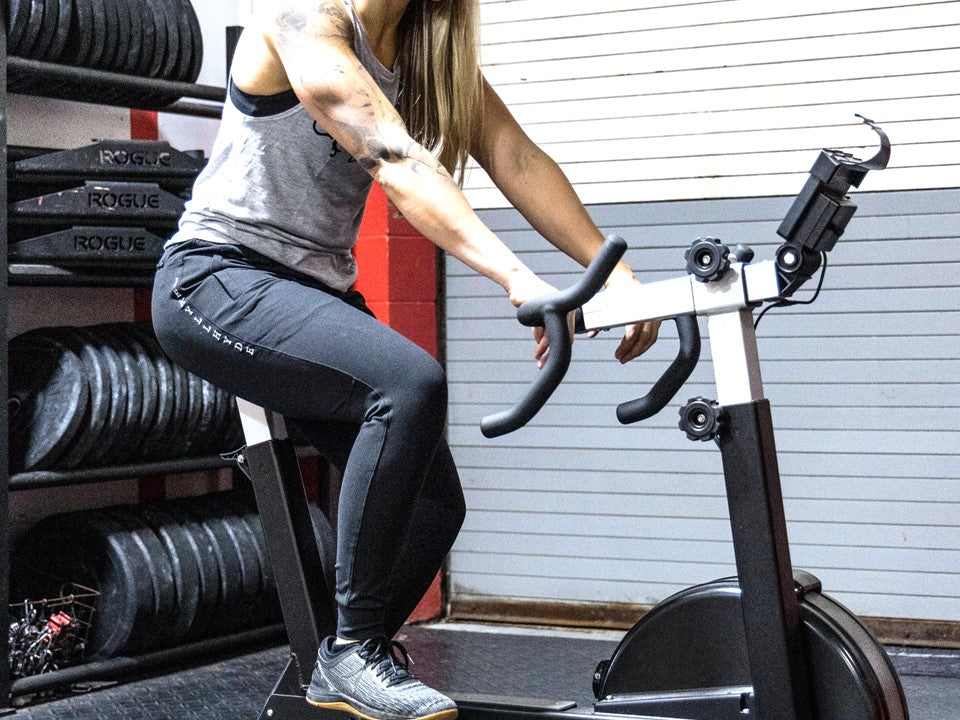 Women on an exercise bike in black joggers. 