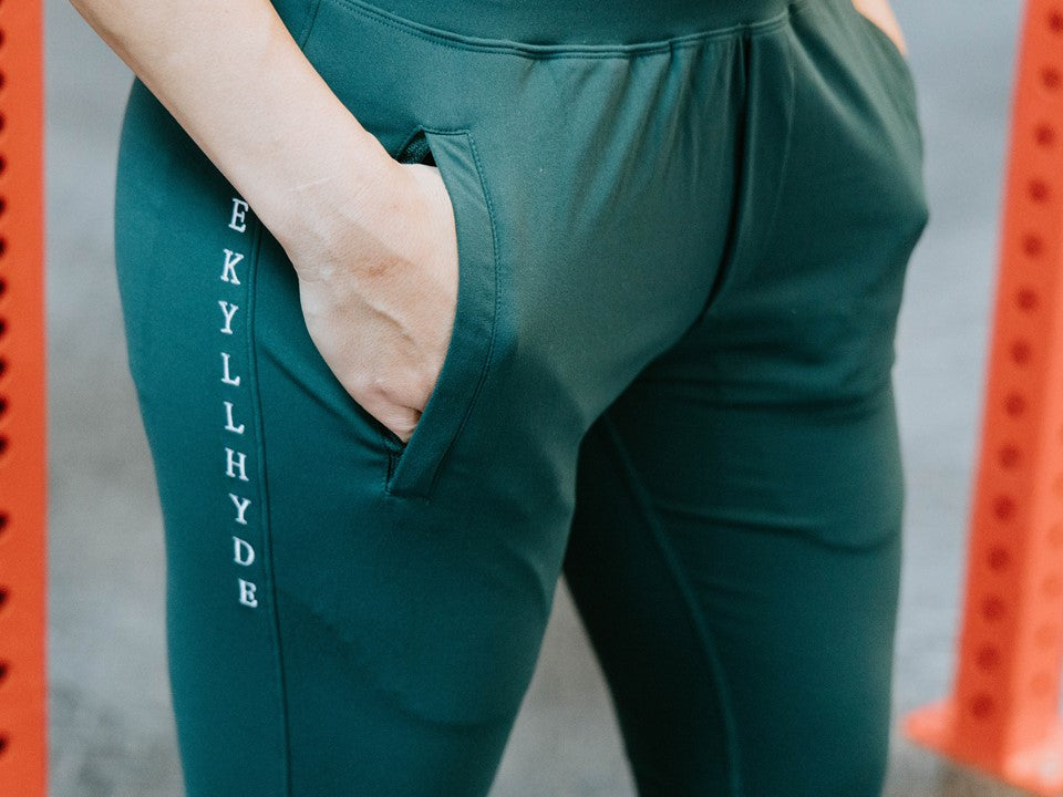 Green joggers with a persons hand in the pocket of that jogger. 